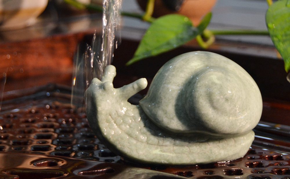茶水從蝸牛茶寵身上流過(guò)